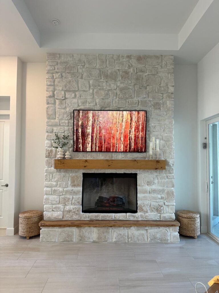 Stone fireplace wall installation near me in Florida with mounted TV and wood mantel
