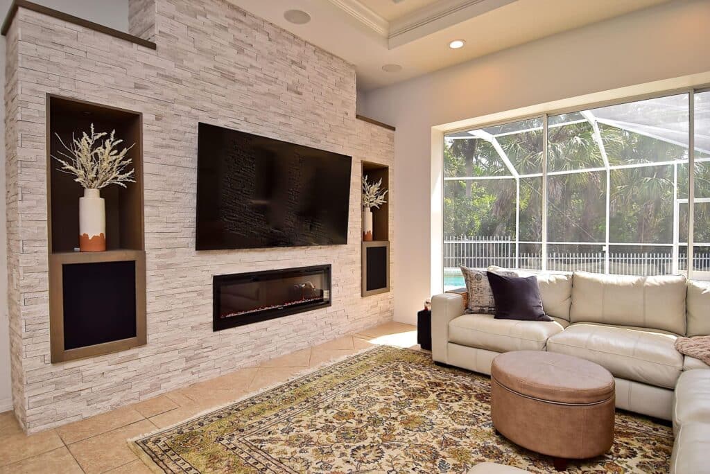 Stone fireplace wall installation in Florida with TV mount and linear electric fireplace near me