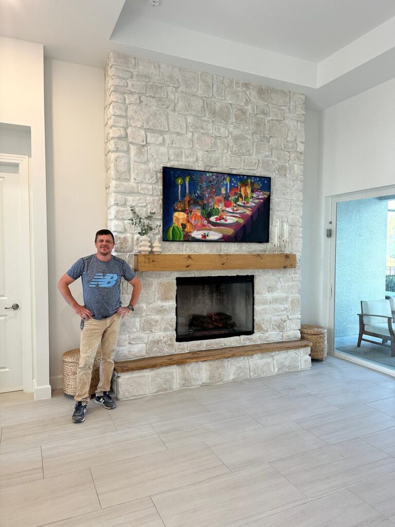 custom stone fireplace wall installation in Orlando with mounted TV and wood mantel
