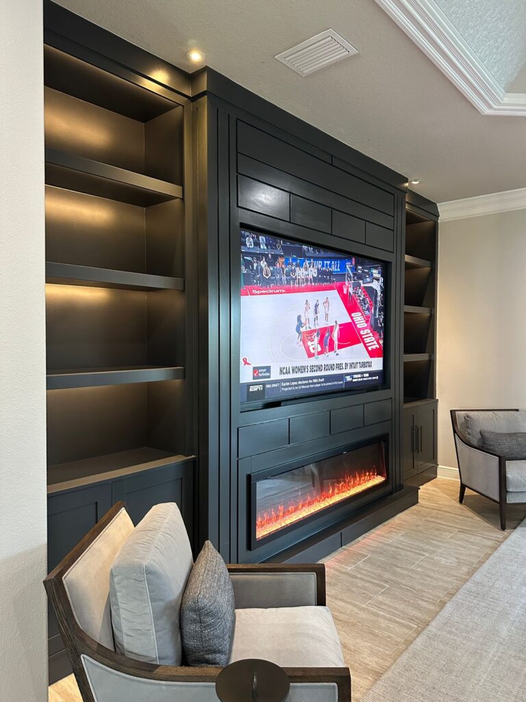 dark media wall with electric fireplace and LED shelves
