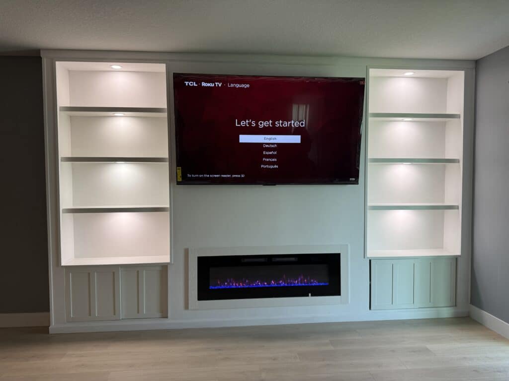 Custom built in TV wall with fireplace and illuminated shelves in Florida home