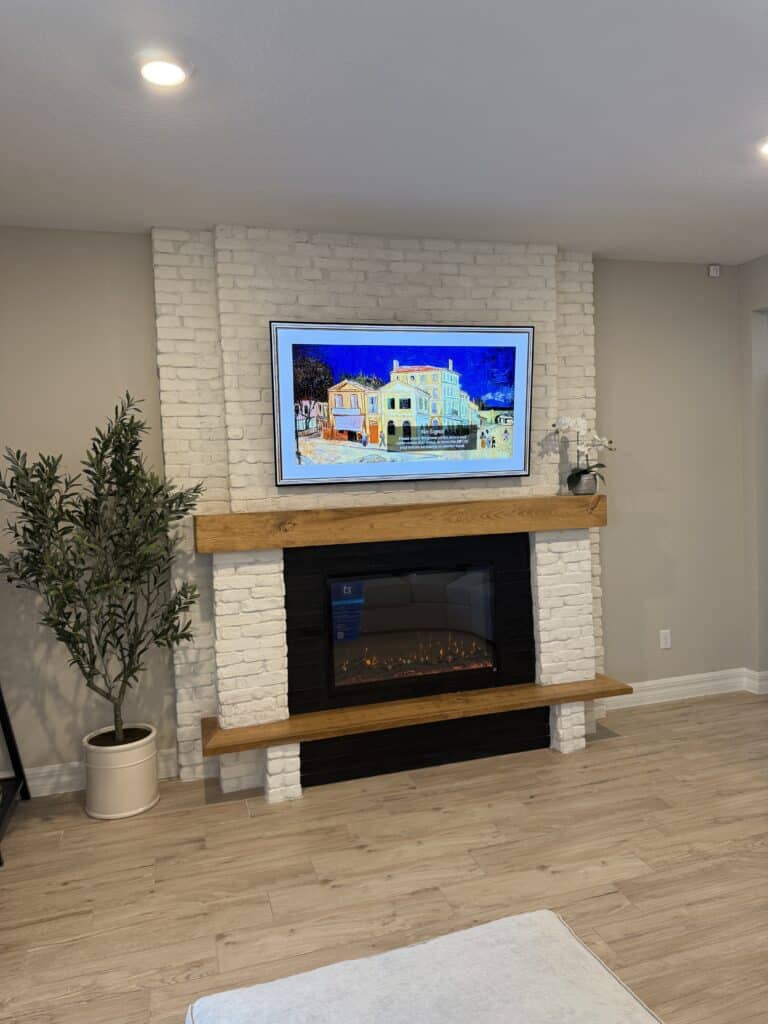 white Chicago brick fireplace wall with mounted TV and floating wood mantel
