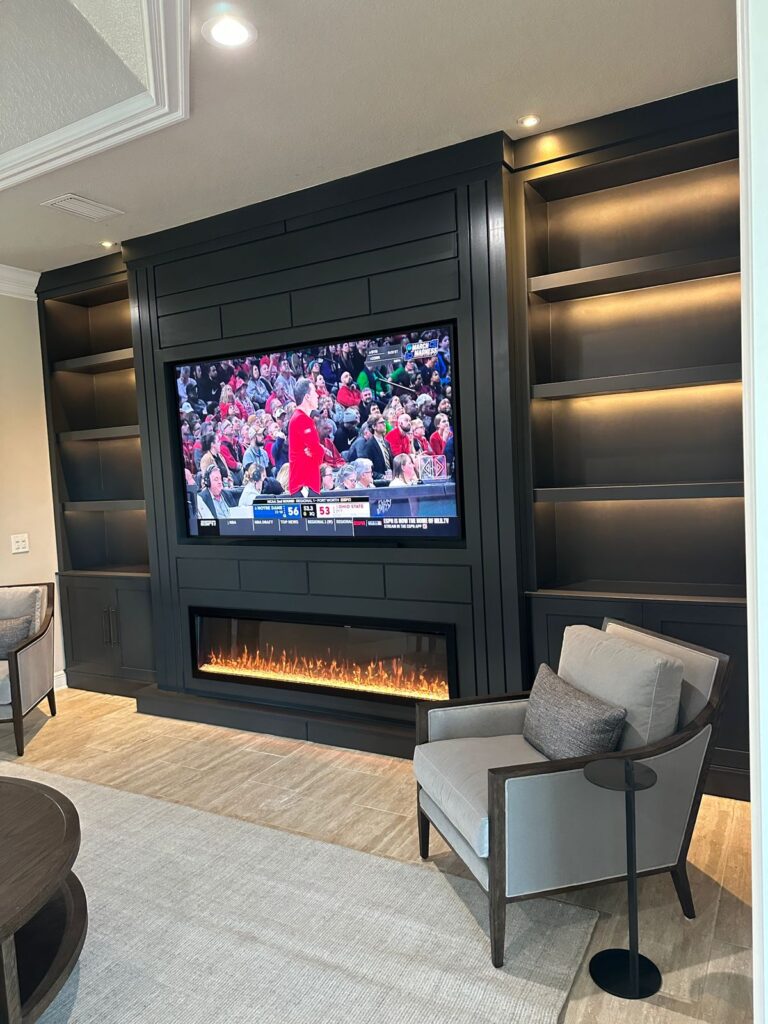 dark media wall with electric fireplace and LED shelves
