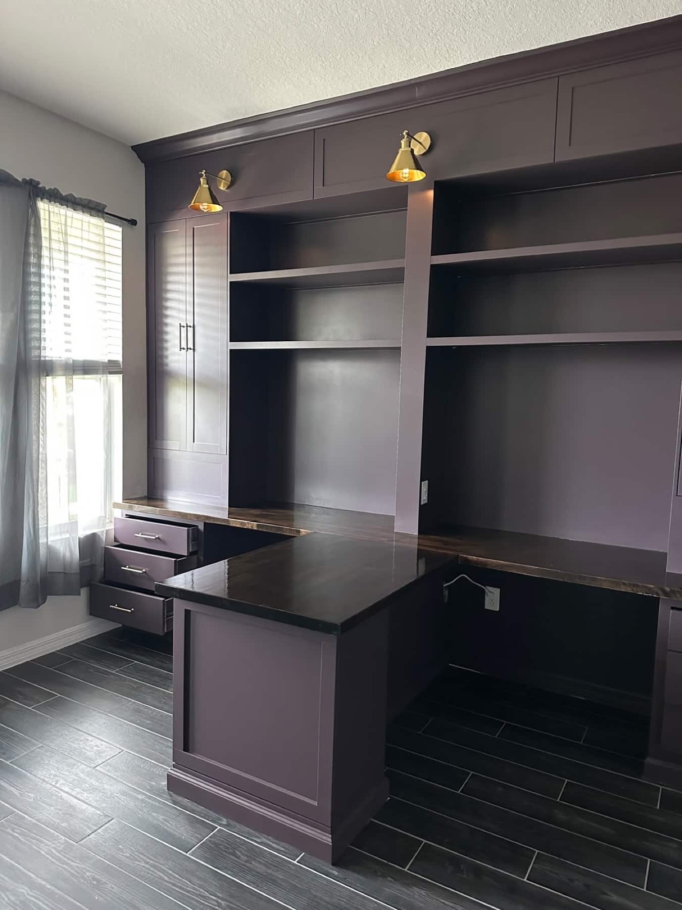 Custom dark built-in cabinetry with integrated desk and brass lighting | fireplace walls florida Custom dark built-in cabinetry with integrated desk and brass lighting — fireplace walls florida