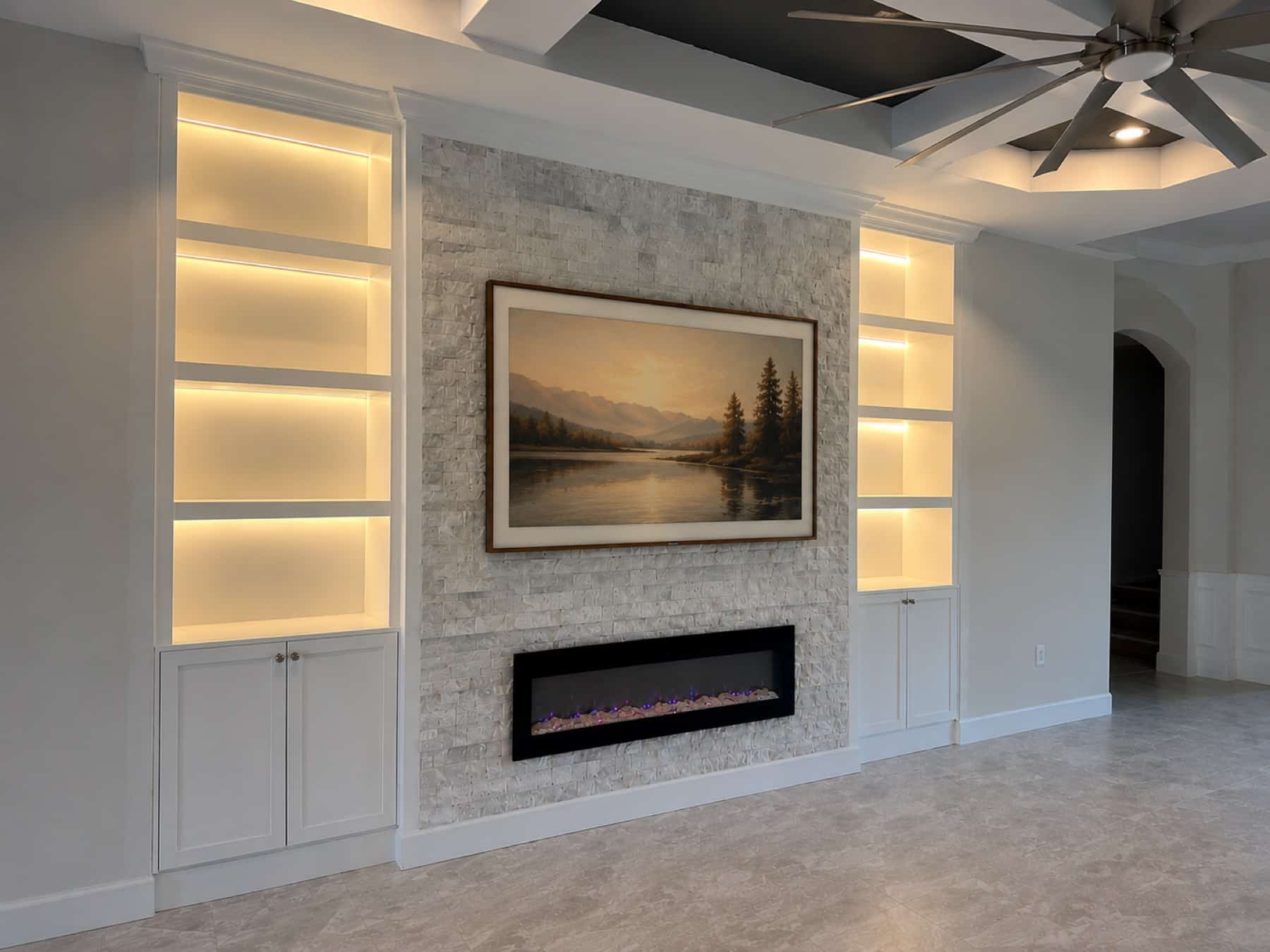 Luxury white built-in fireplace media wall with illuminated shelving in Florida — fireplace walls florida