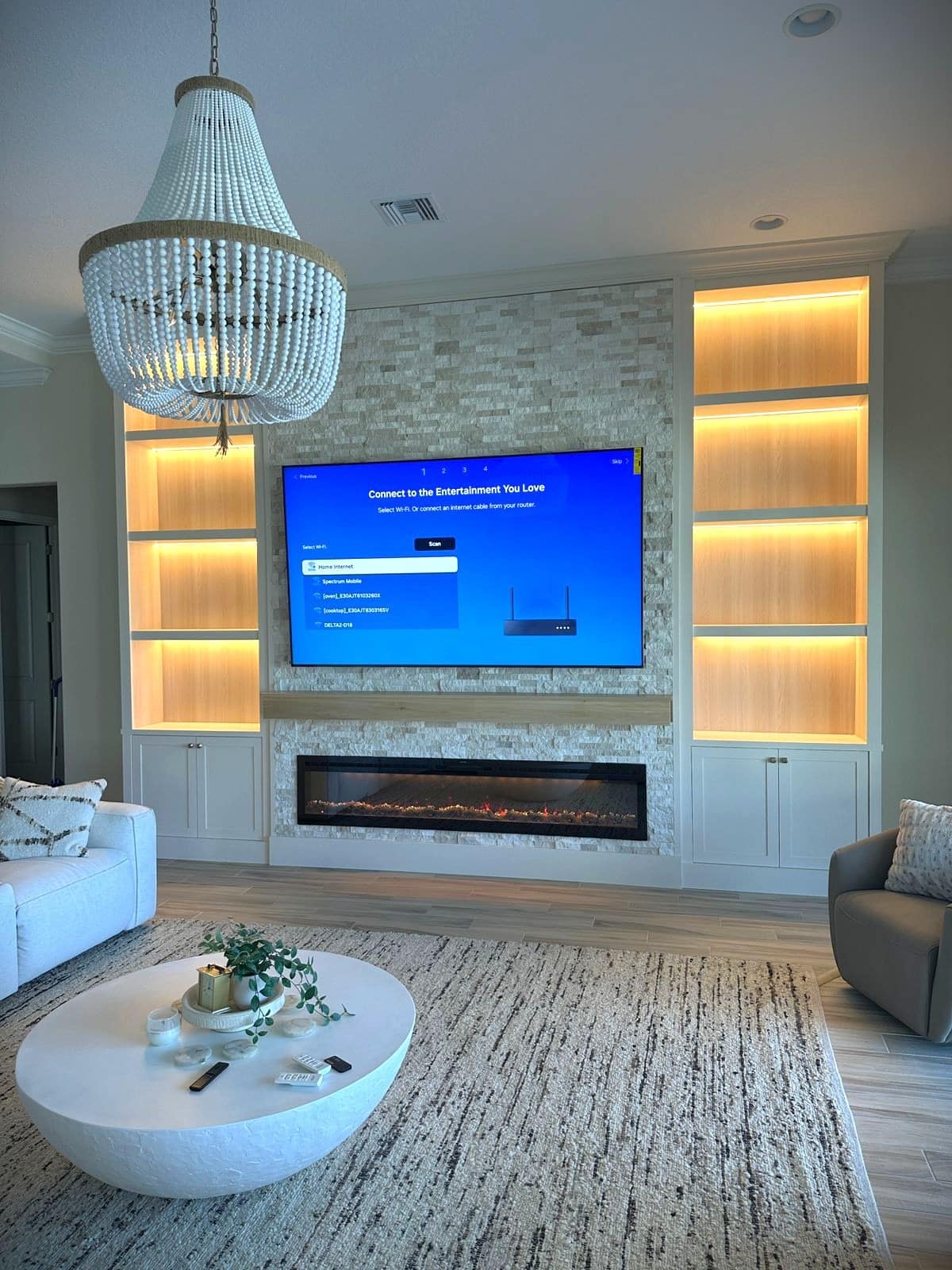 Luxury stone media wall with illuminated built-in cabinetry — fireplace wall projects florida
