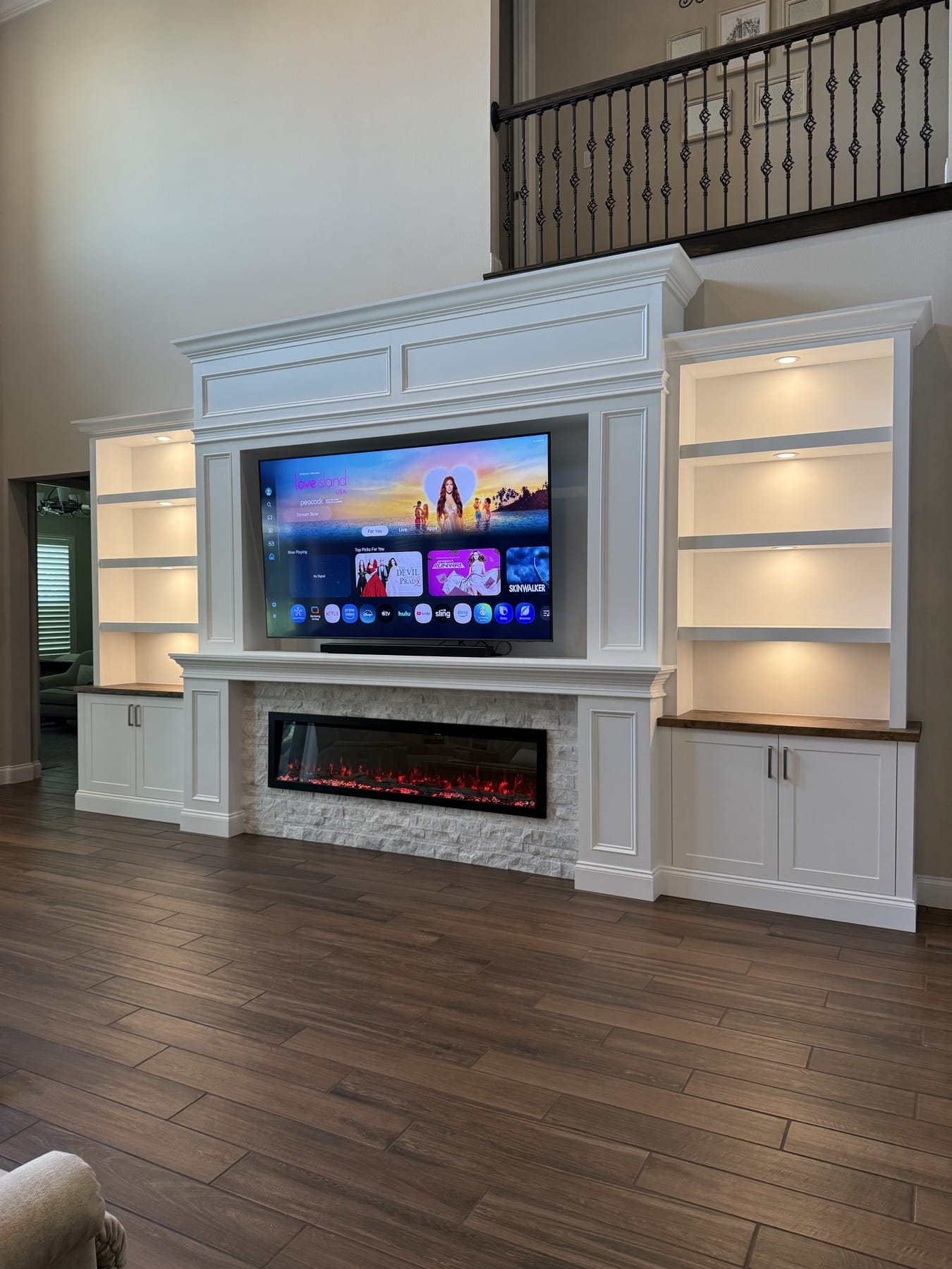 Classic white fireplace media wall with illuminated built-ins — fireplace walls florida